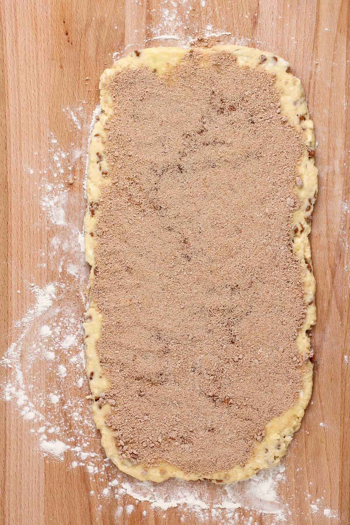 Cinnamon scone dough rolled into a rectangle and topped with melted butter and cinnamon-sugar filling.