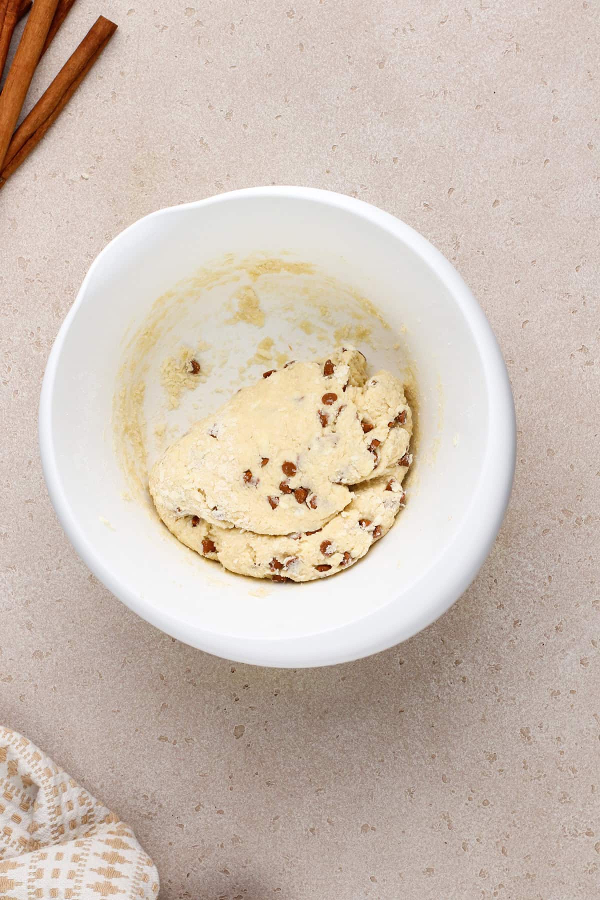 Cinnamon scone dough pressed into a ball in a white bowl.