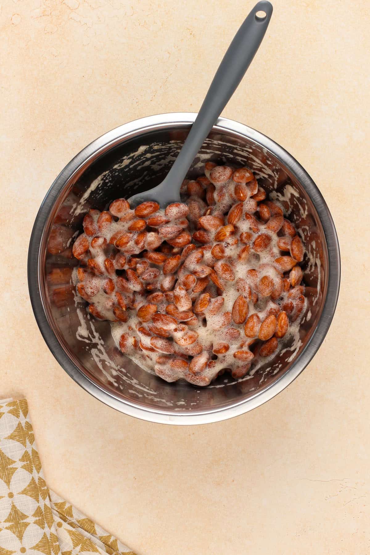 Whole almonds coated in the egg white base for candied almonds.