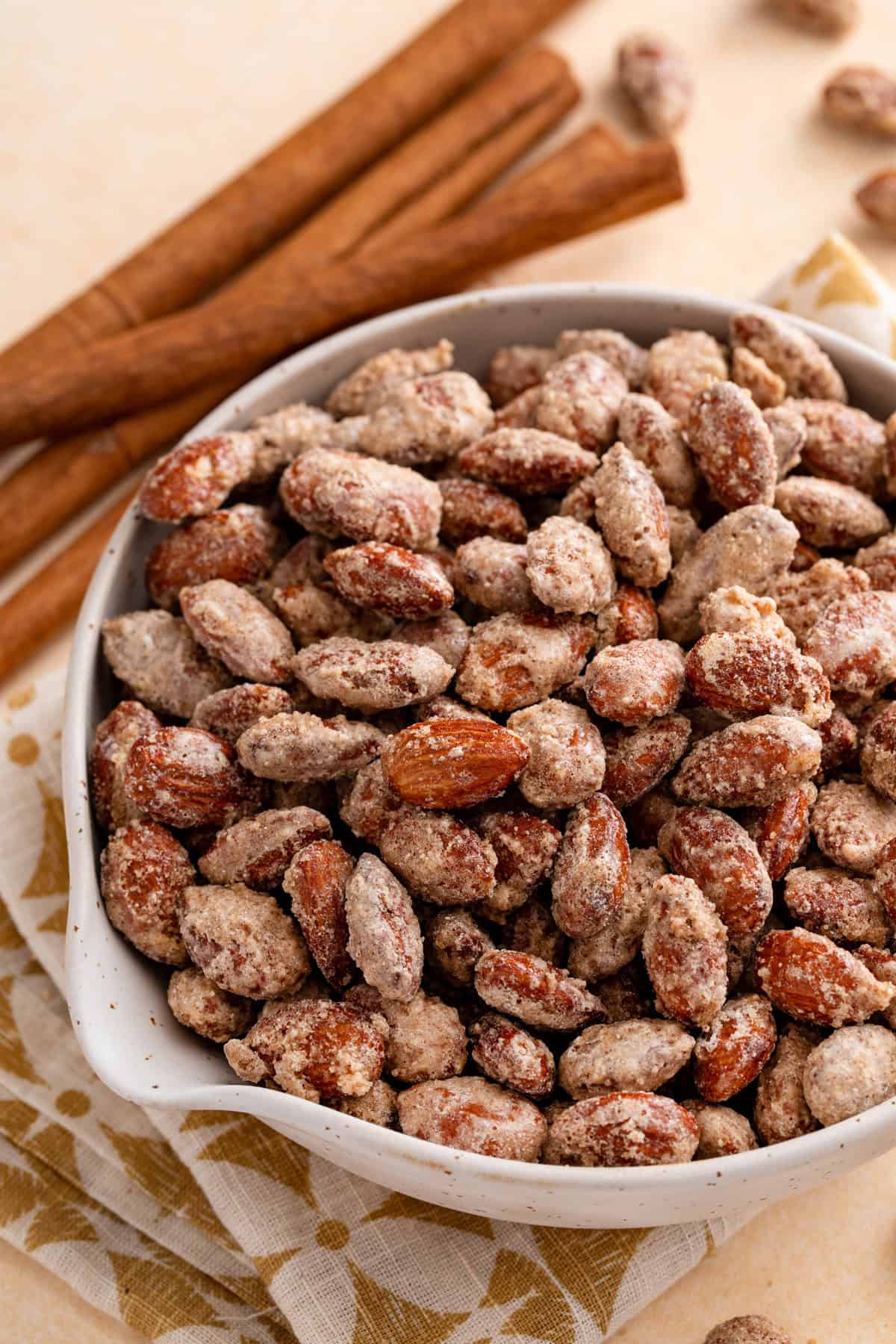 Close up of candied almonds in a white bowl.