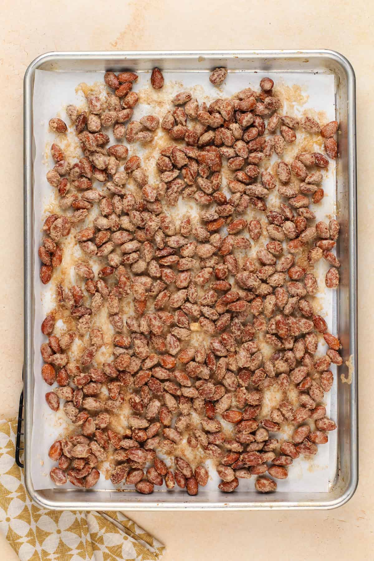 Roasted candied almonds fresh from the oven on a sheet pan.