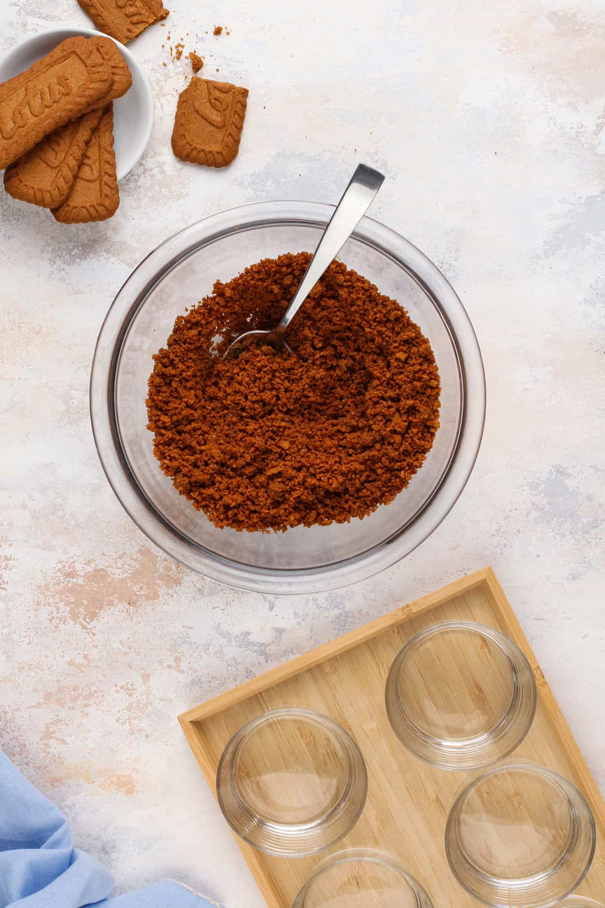 Mixture for biscoff crust in a glass bowl.