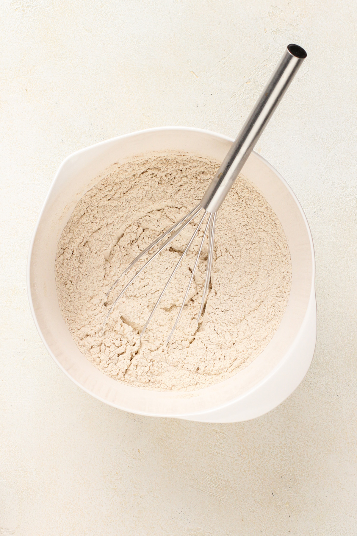 Molasses cookie dry ingredients whisked in a mixing bowl.