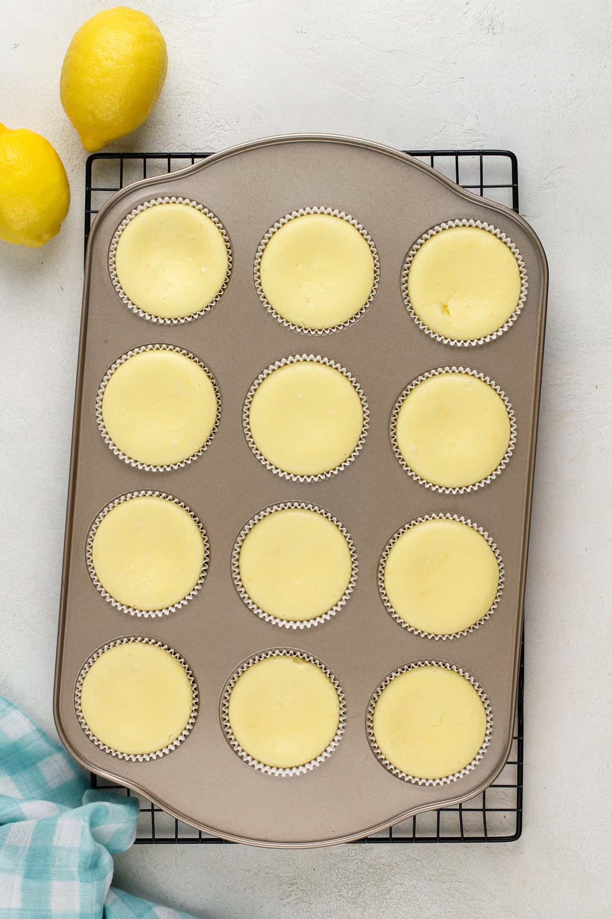 baked and cooled mini lemon cheesecakes in a muffin pan.