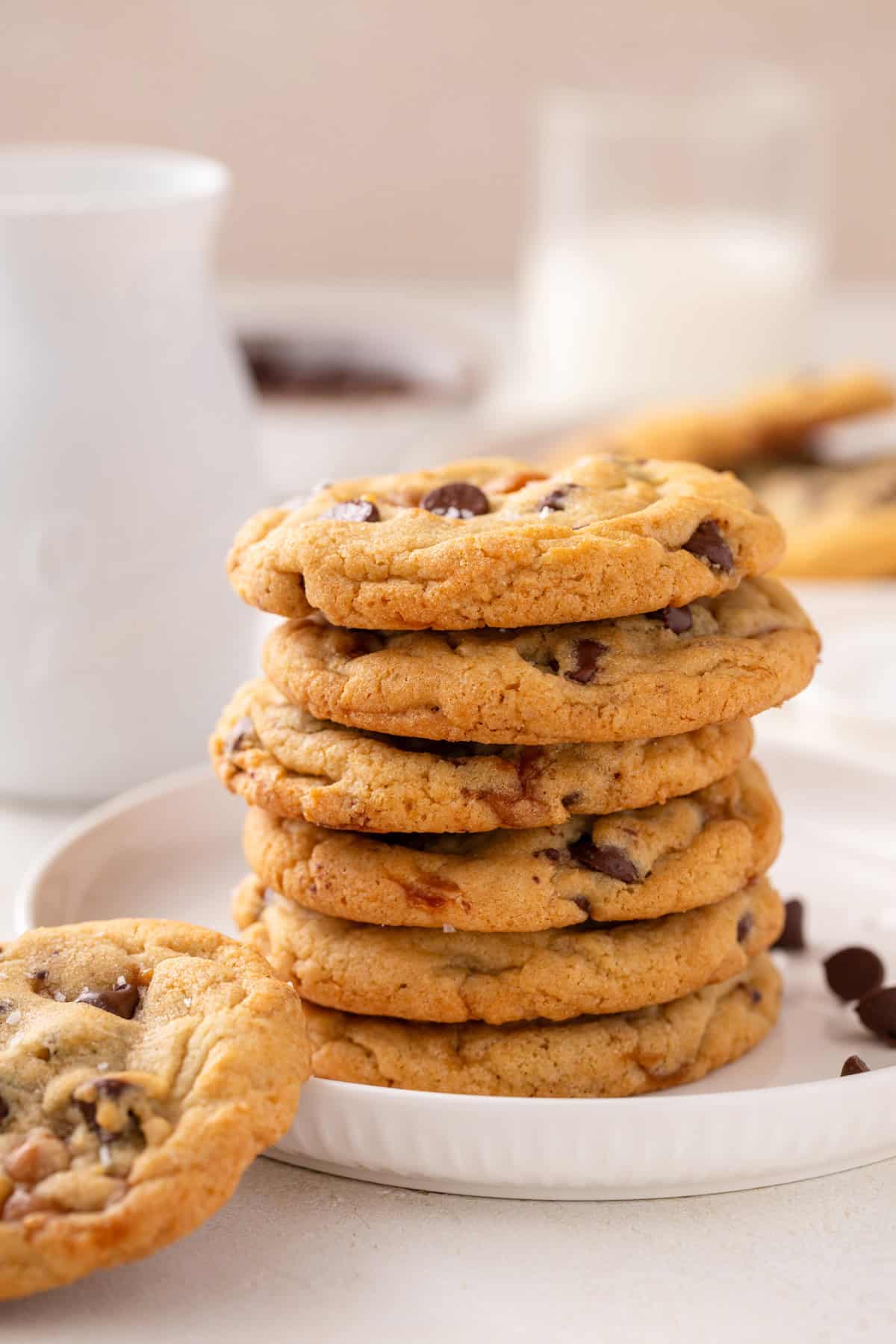 Stack of salted caramel chocolate chip cookies on a white plate.