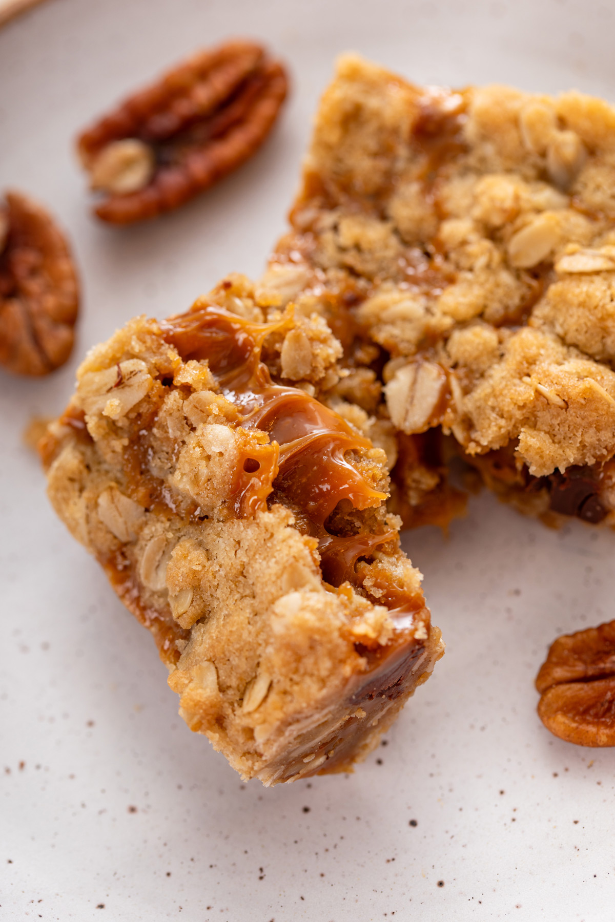 Halved caramel pecan bar showing the gooey caramel in the middle.