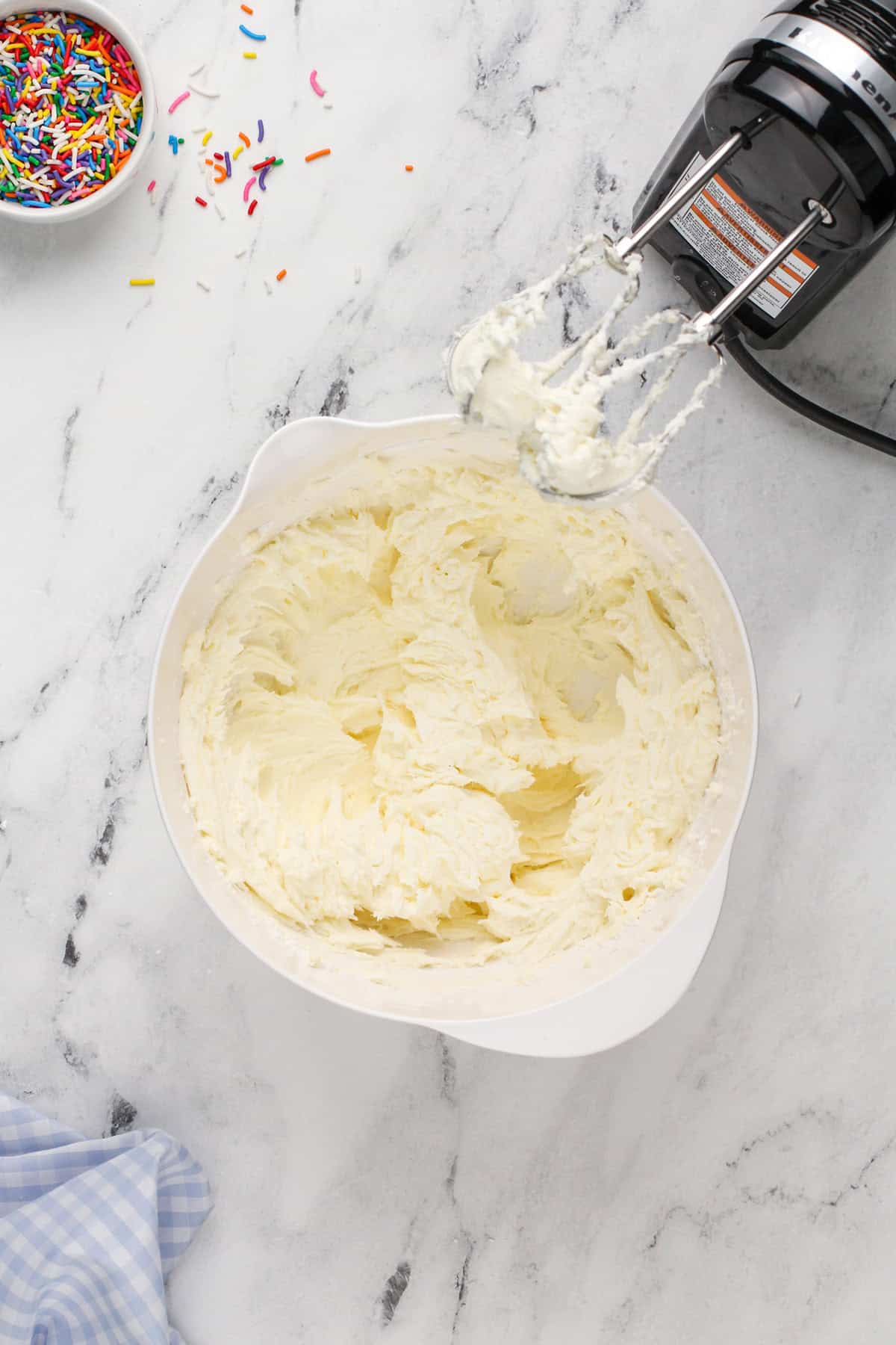 Buttercream frosting in a white mixing bowl.