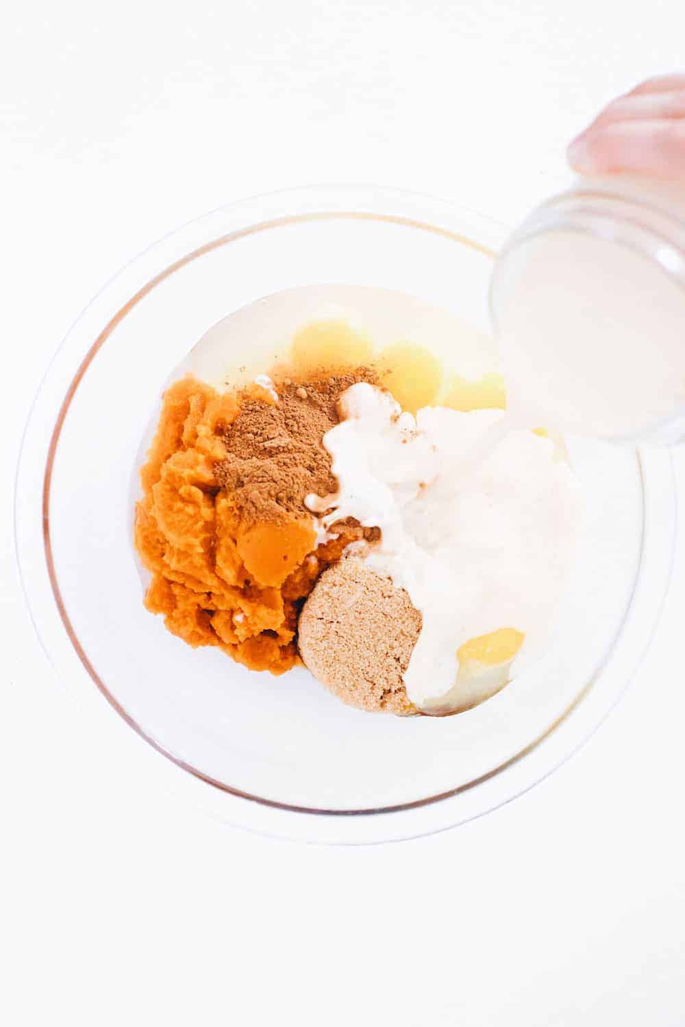 Ingrédients du gâteau Crunch à la citrouille dans un bol à mélanger en verre sur le comptoir