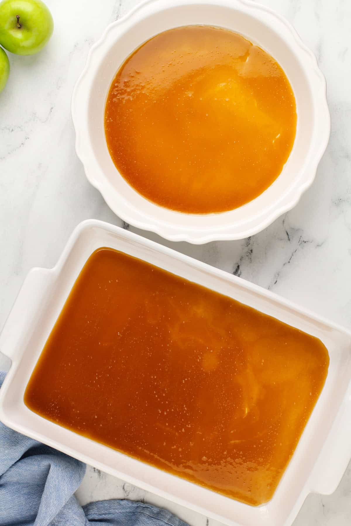 Caramel sauce poured into two baking pans.