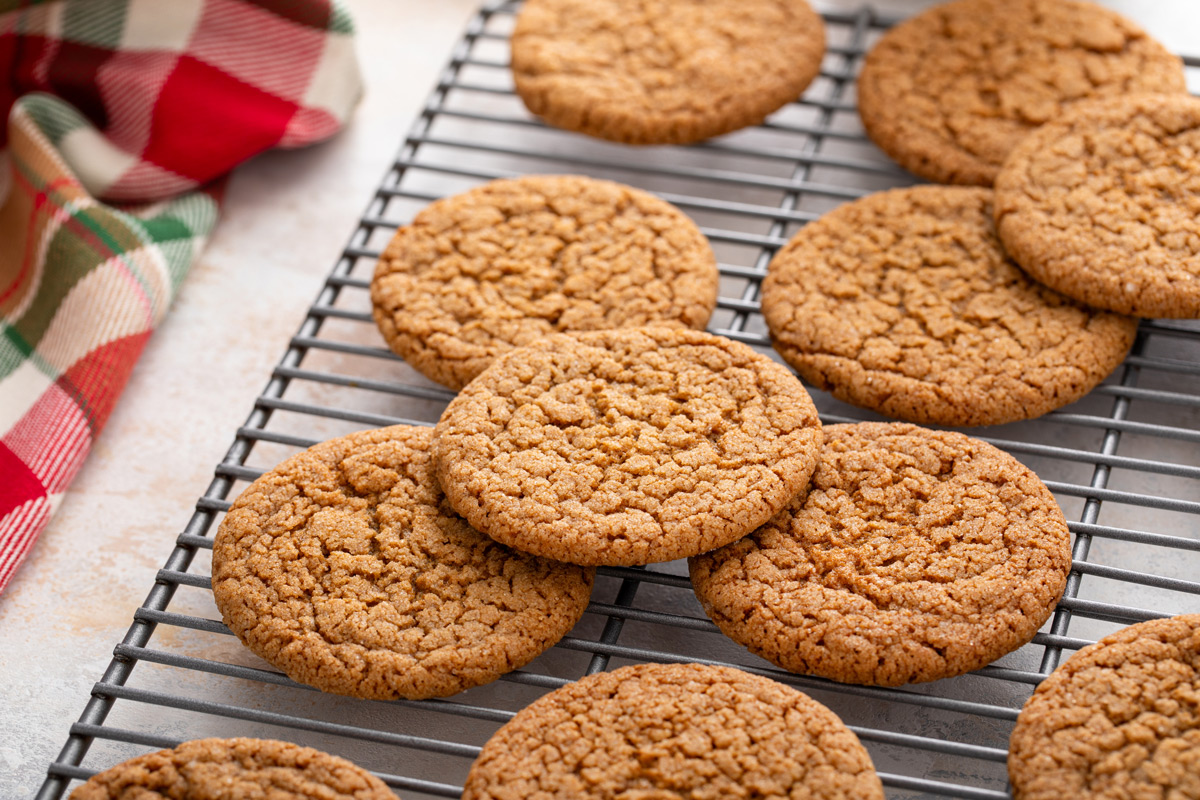 Close up of gingersnap cookies cooling on a wire rack.