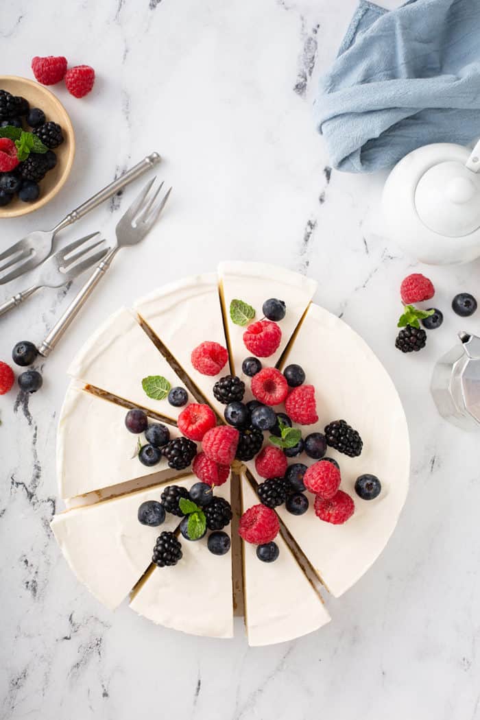 Overhead view of a sliced no-bake frozen cheesecake, garnished with fresh mixed berries