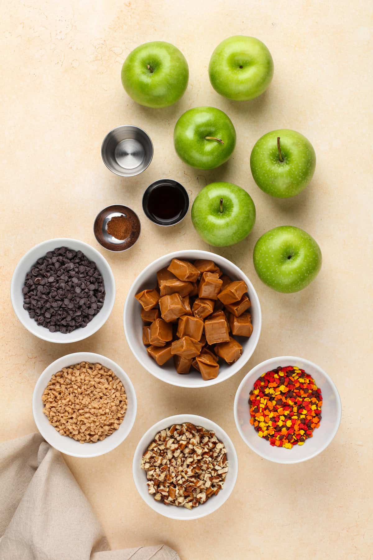 Ingredients for homemade caramel apples arranged on a countertop.