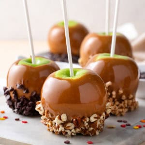 Homemade caramel apples on a marble board.