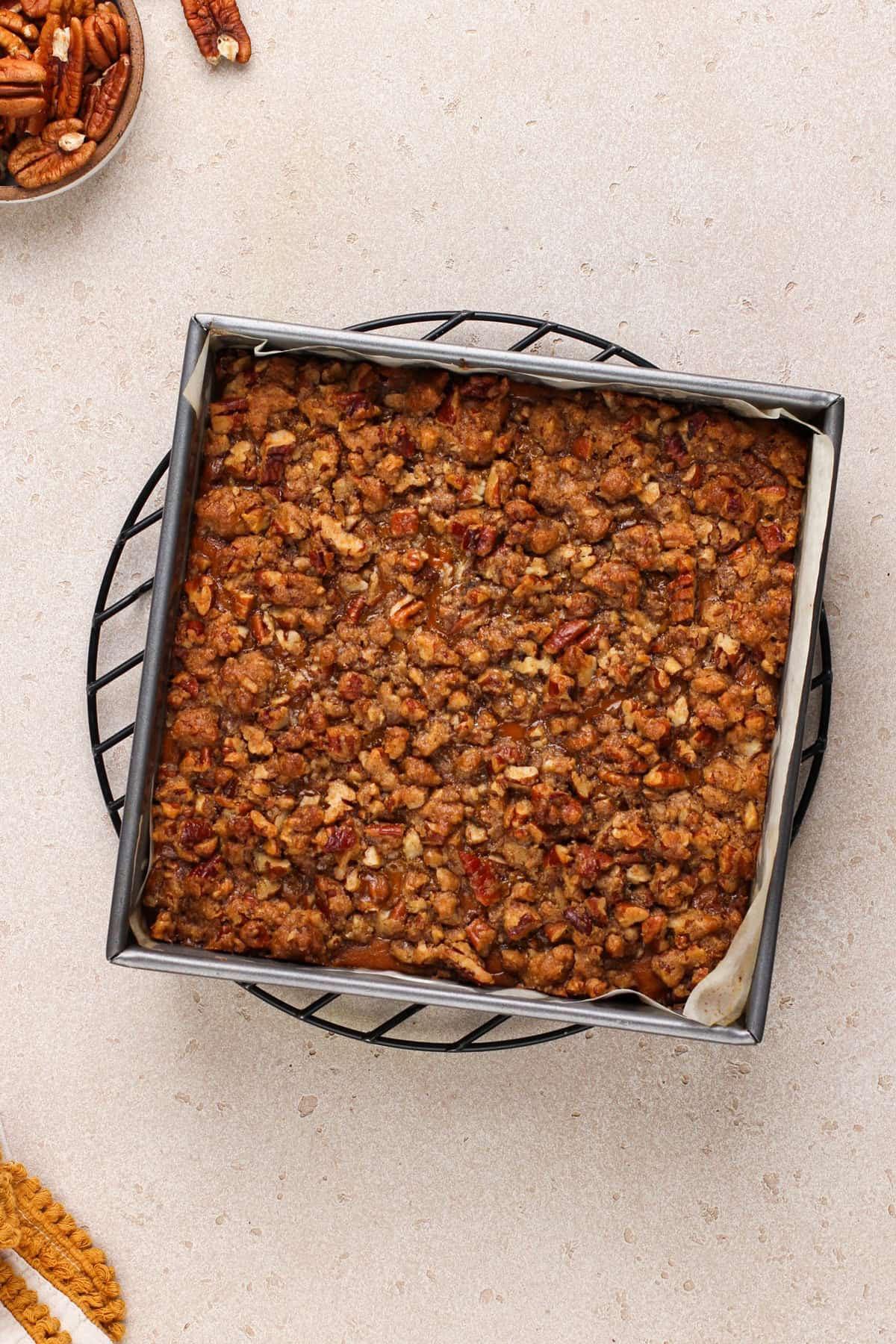 Baked and cooling pumpkin pecan pie bars on a wire rack.