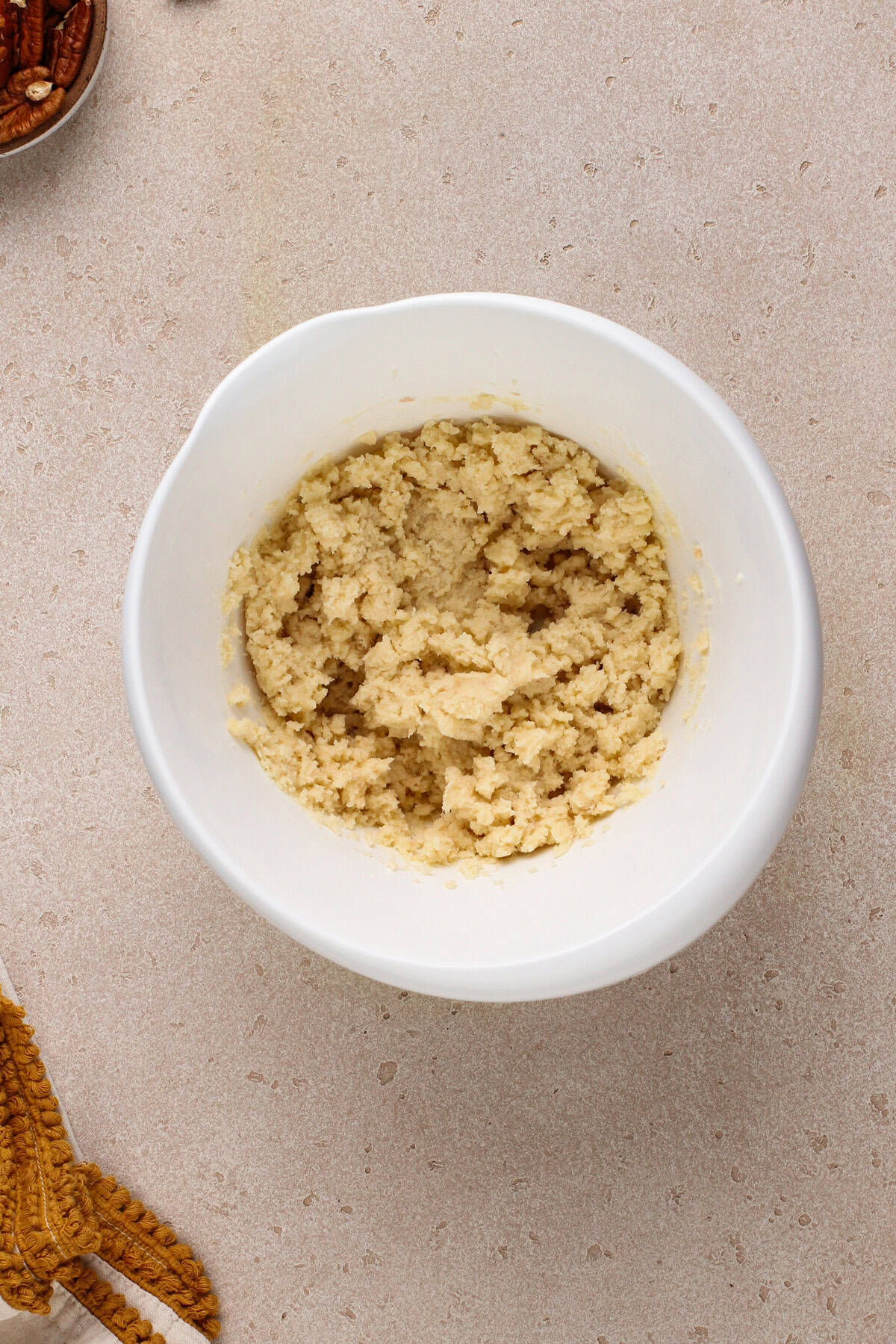 Crust mixture for pumpkin pecan bars in a white bowl.