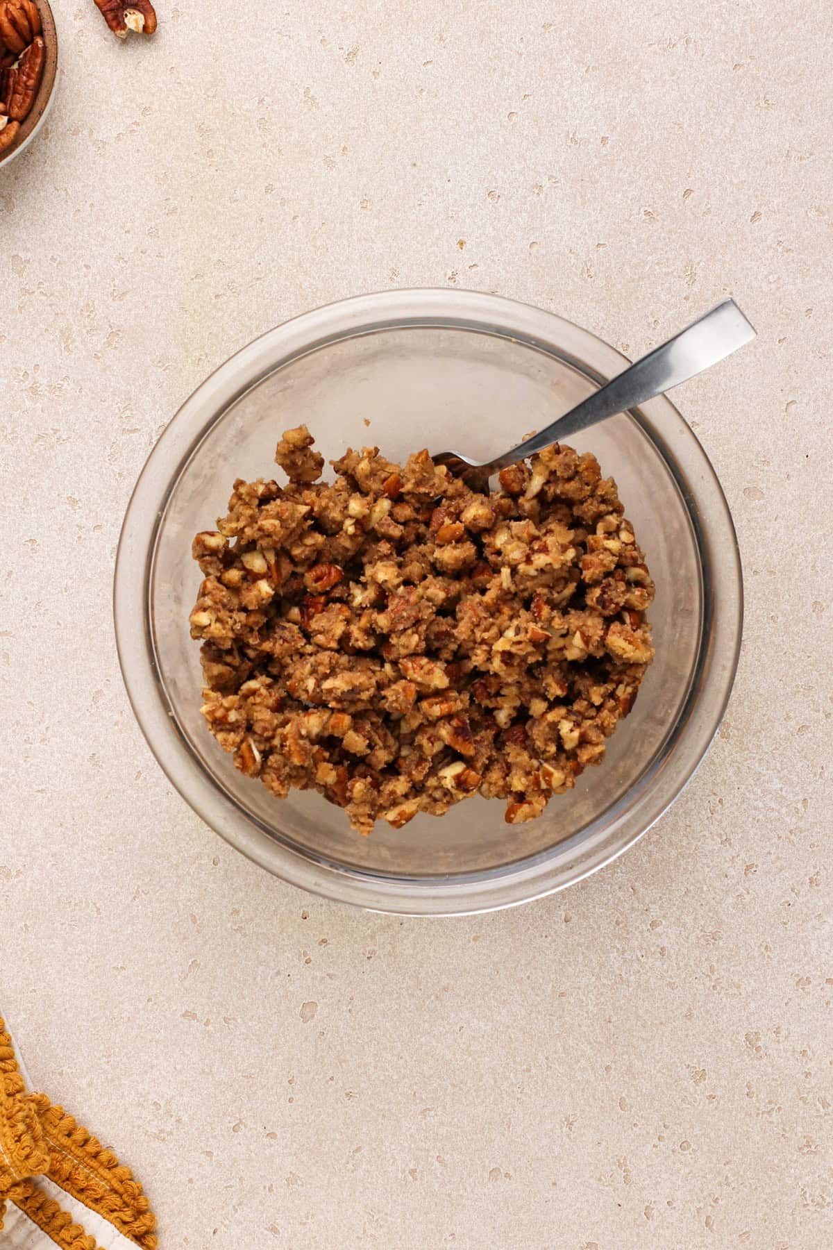 Pecan streusel topping mixture in a glass mixing bowl.