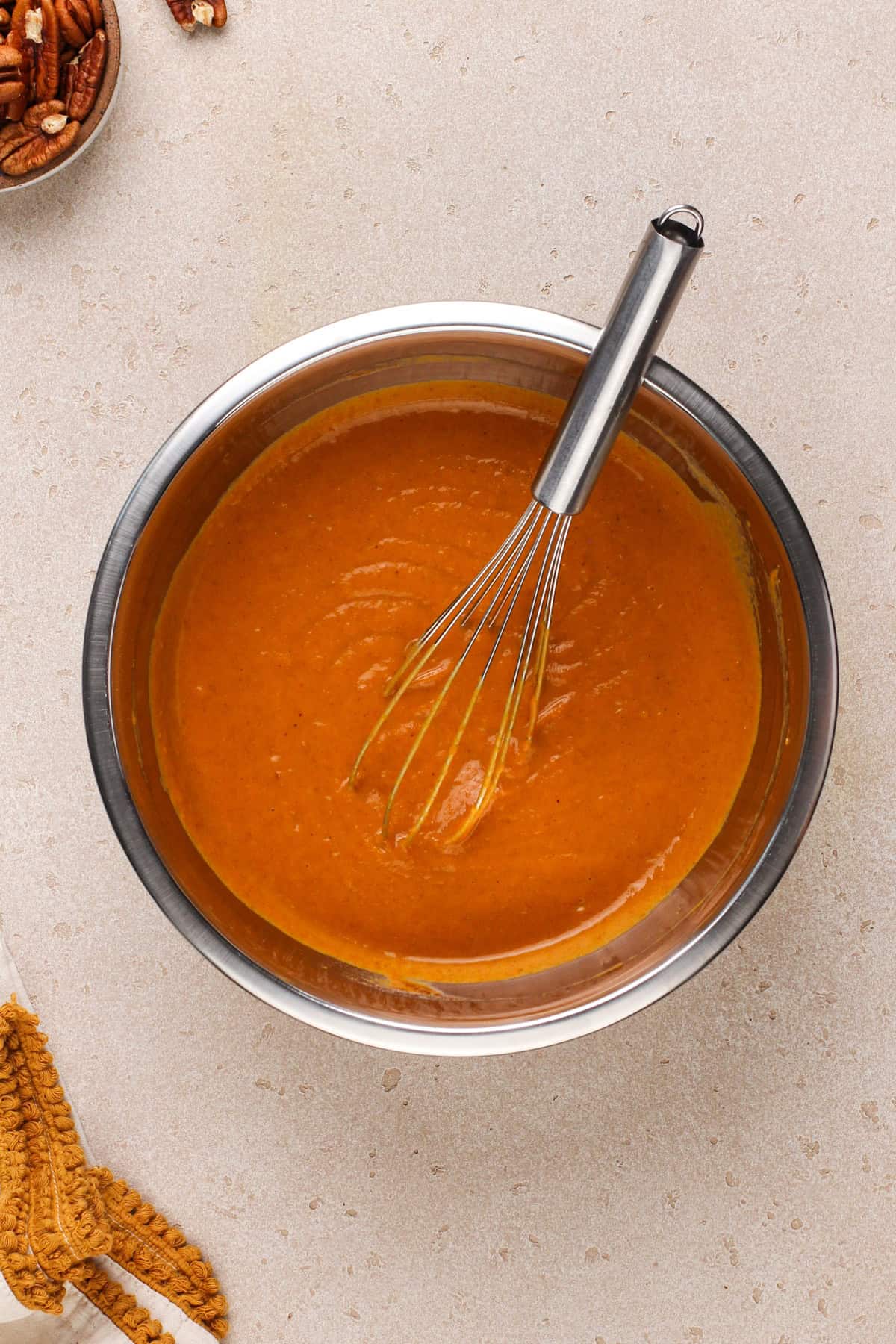 Pumpkin pie filling in a metal mixing bowl.