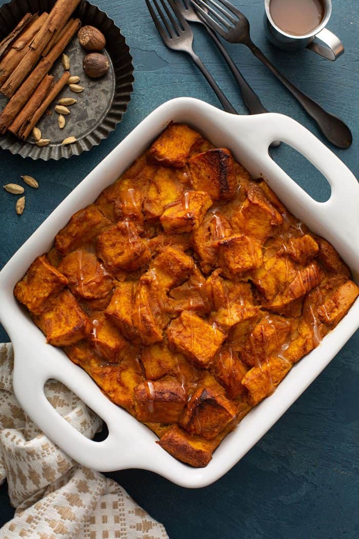Overhead view of baked pumpkin bread pudding in a white baking dish
