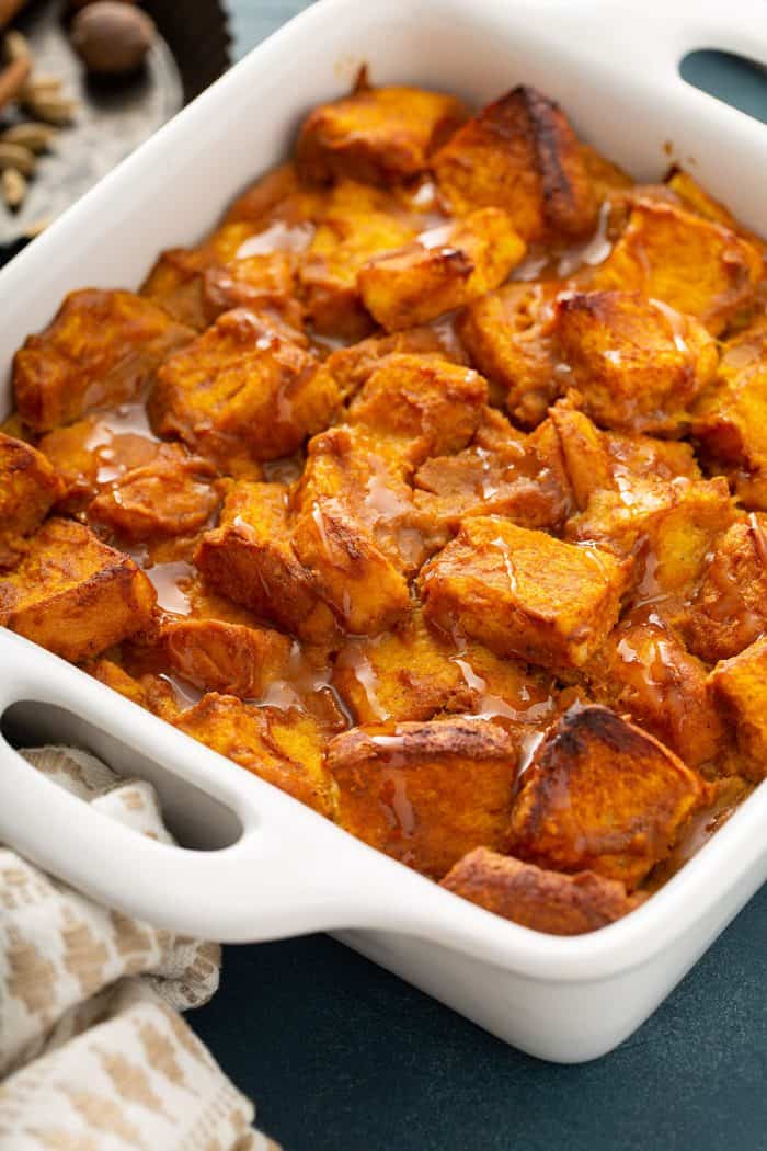 Close-up of baked pumpkin bread pudding in a white baking dish