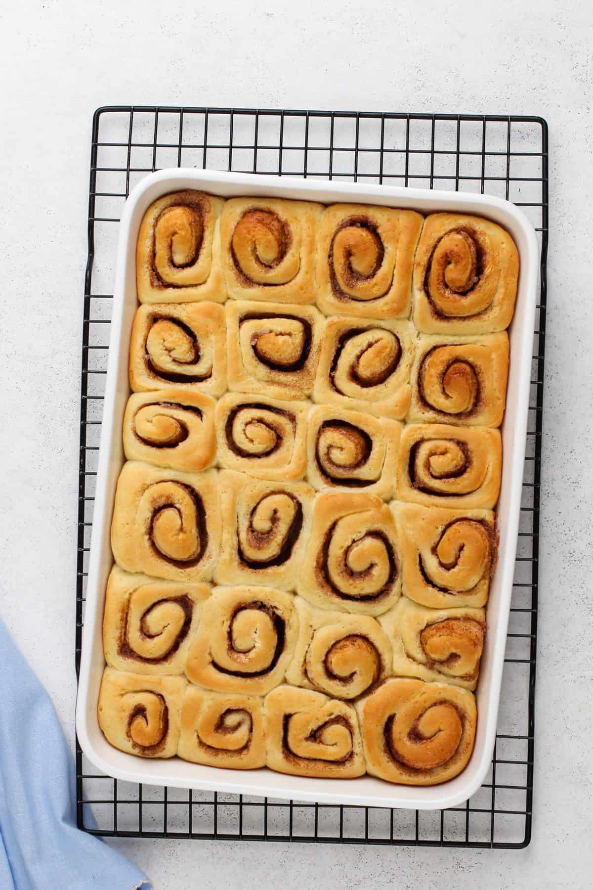 Baked mini cinnamon rolls in a white baking dish.