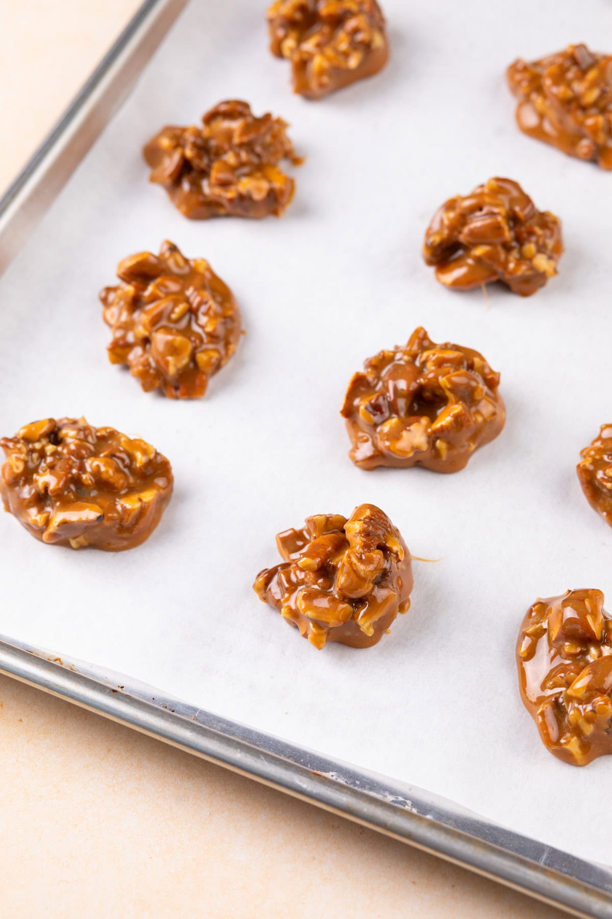 Caramel pecan mixture divided onto parchment paper.