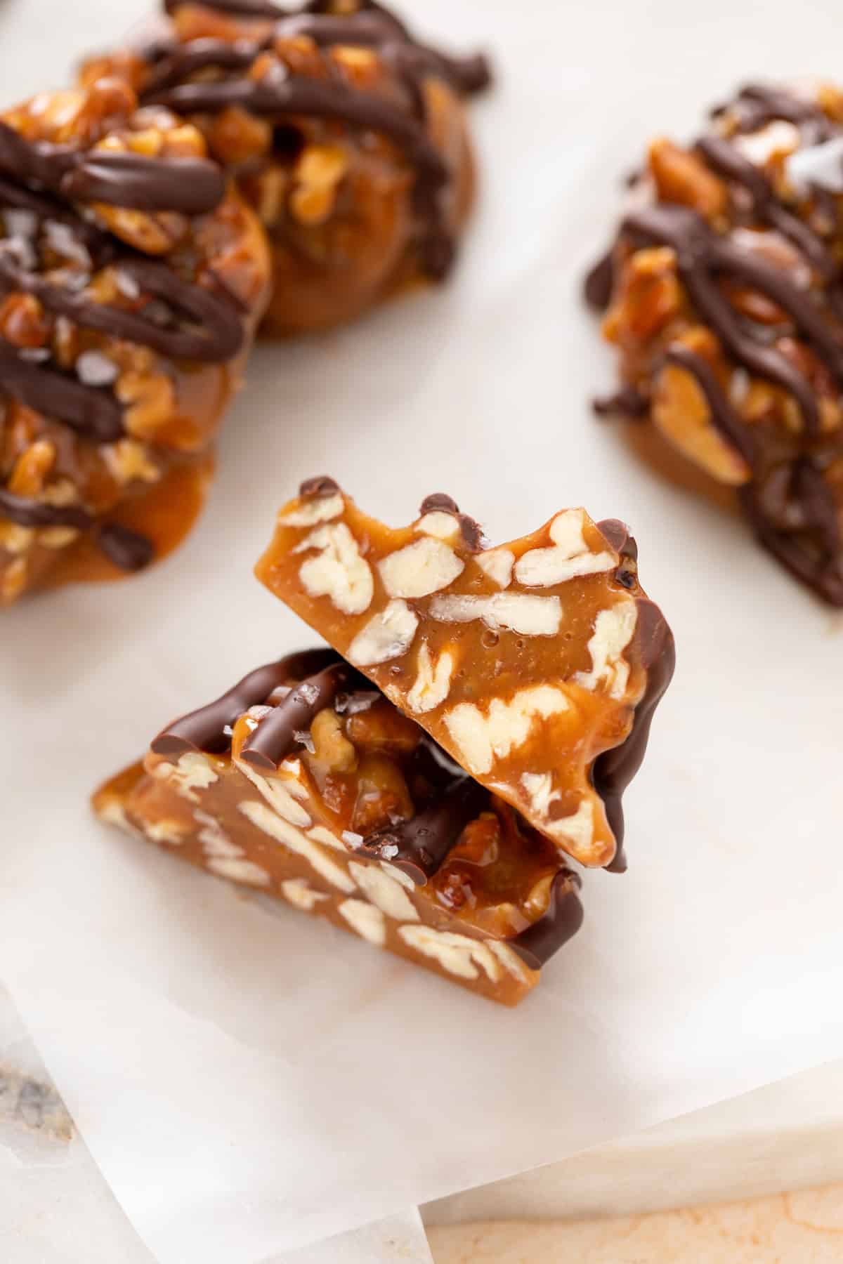 Pecan caramel cluster cut in half to show the pecan pieces on the inside.