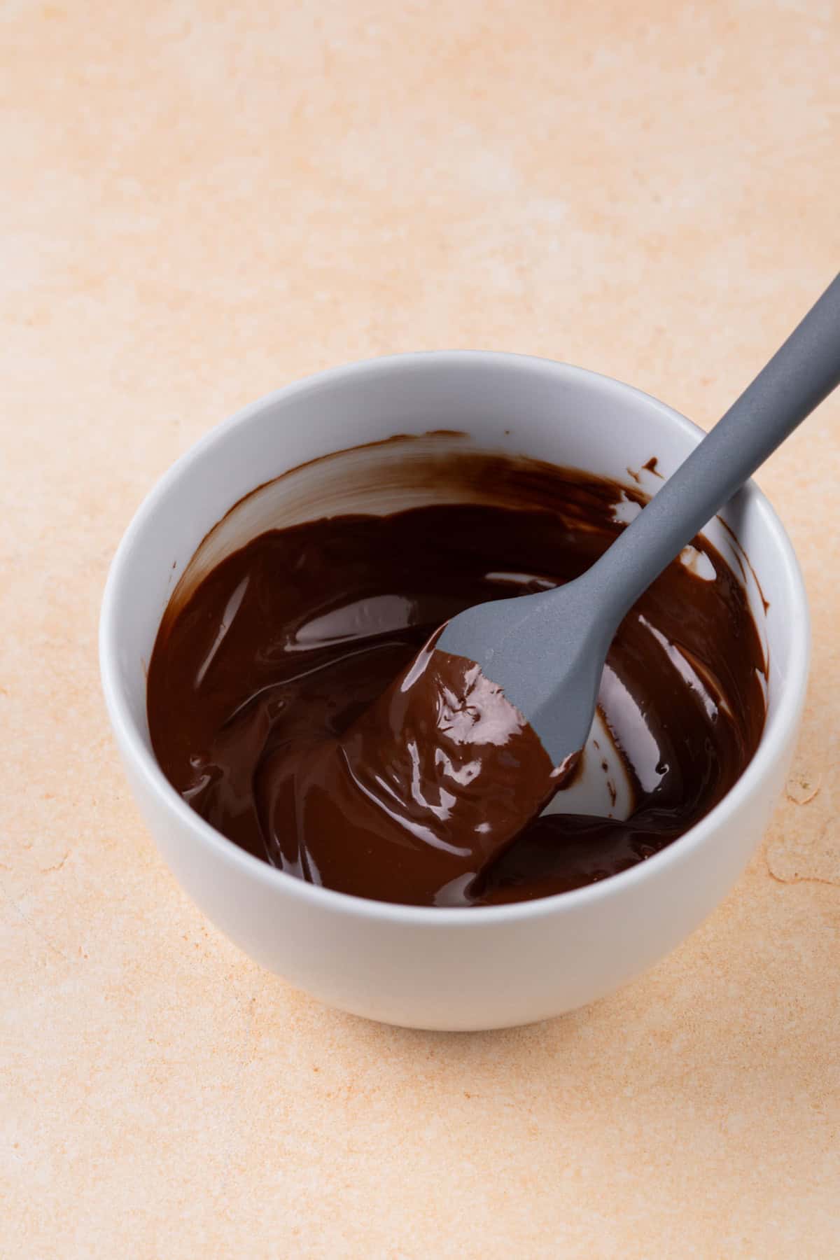 Melted chocolate being stirred in a small bowl.