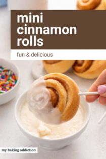 Hand dipping a mini cinnamon roll on a lollipop stick into a bowl of glaze. Text overlay includes recipe name.