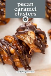 Close up of two pecan caramel clusters, with a bite taken from one of them. Text overlay includes recipe name.