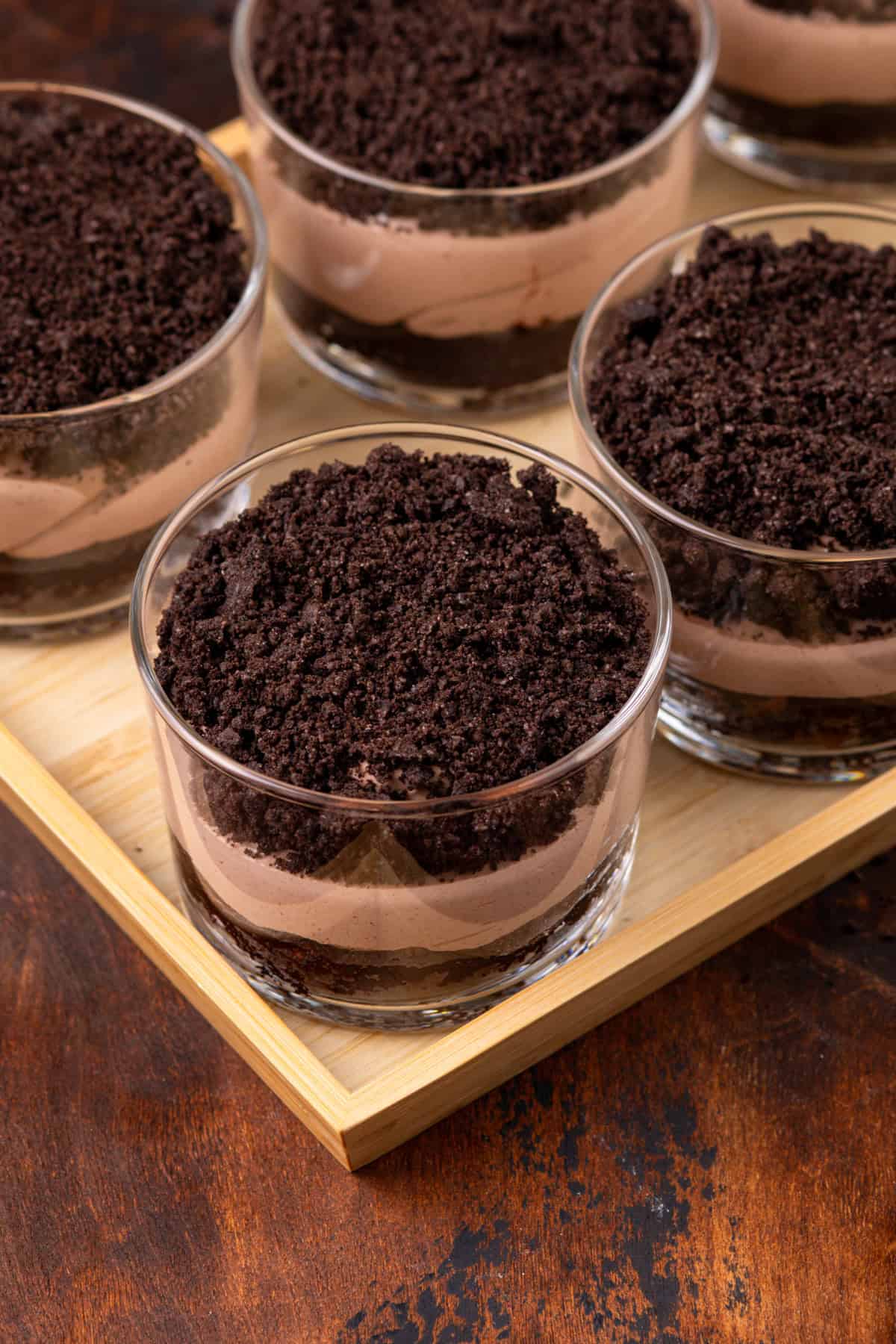 Assembled brownie dirt puddings in individual serving dishes.