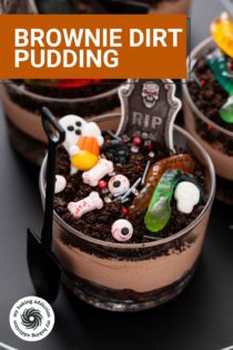 Close up of a brownie dirt pudding decorated with Halloween candies. Text overlay includes recipe name.