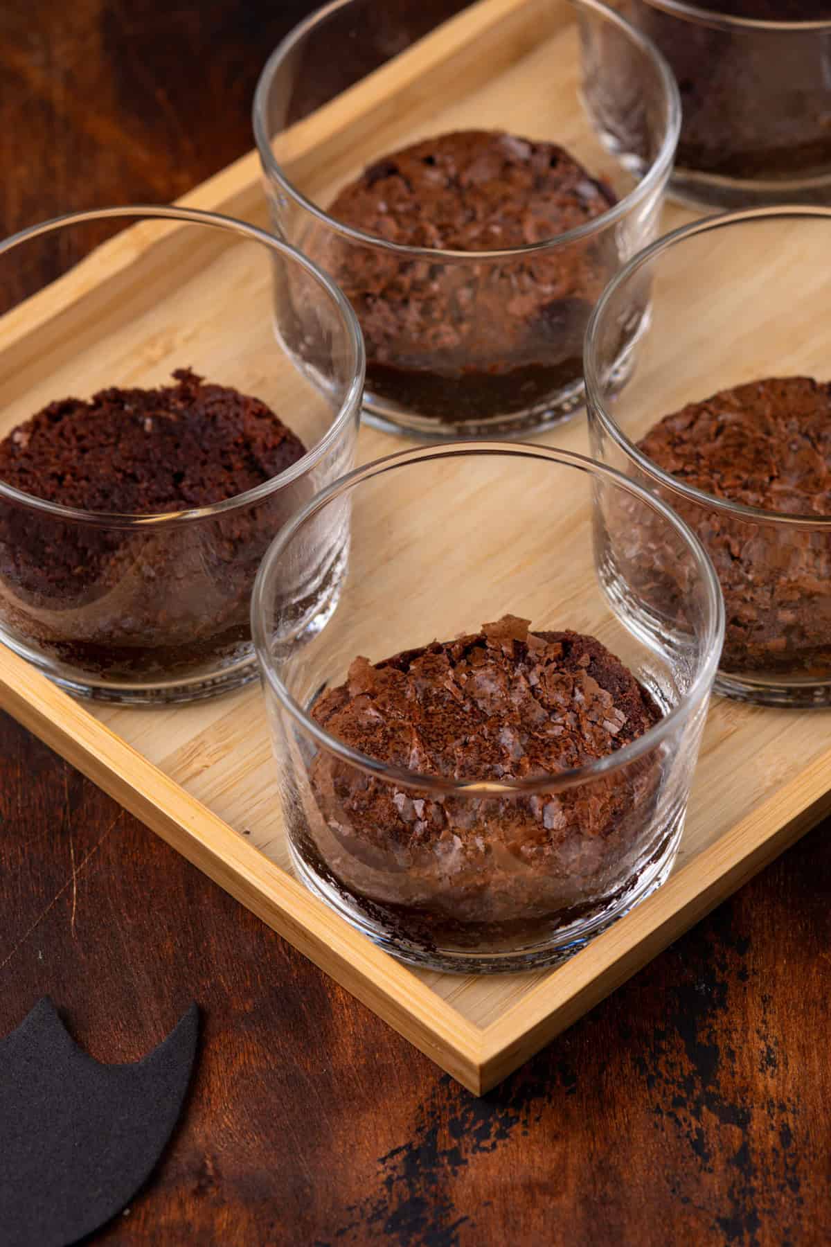 Halved brownie rounds in the bottom of glass serving dishes.