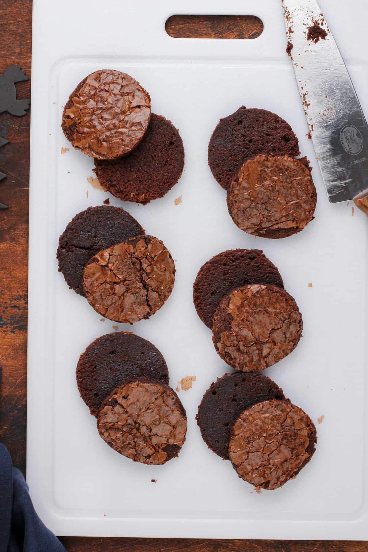 Brownie rounds cut in half horizontally and resting on a white cutting board.