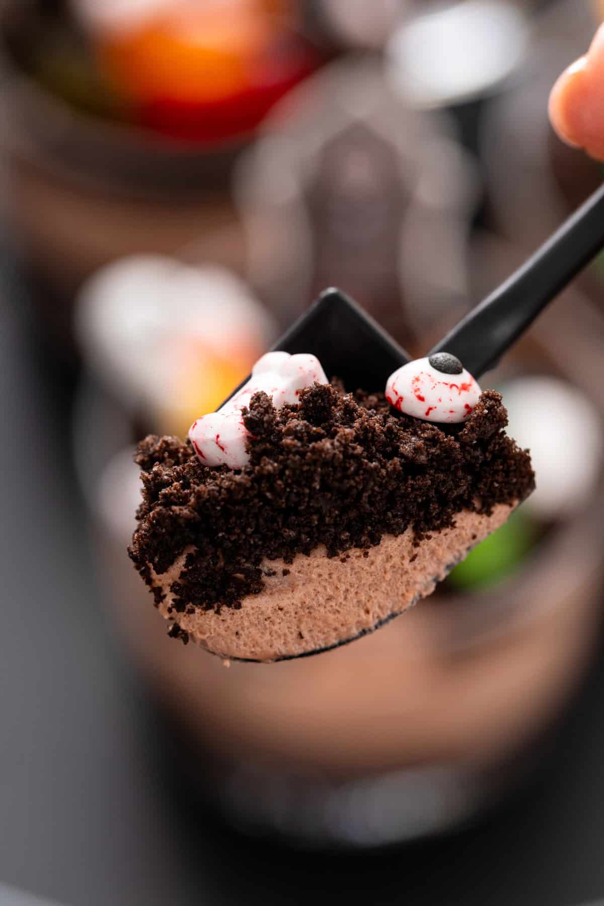 Shovel-shaped spoon holding up a bite of brownie dirt pudding.