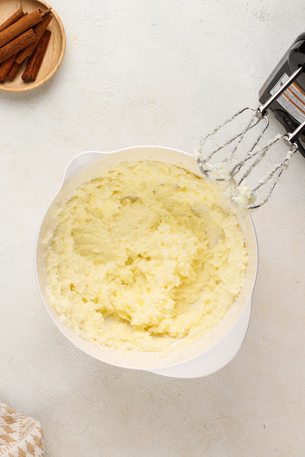 Butter and sugar creamed in a white mixing bowl.