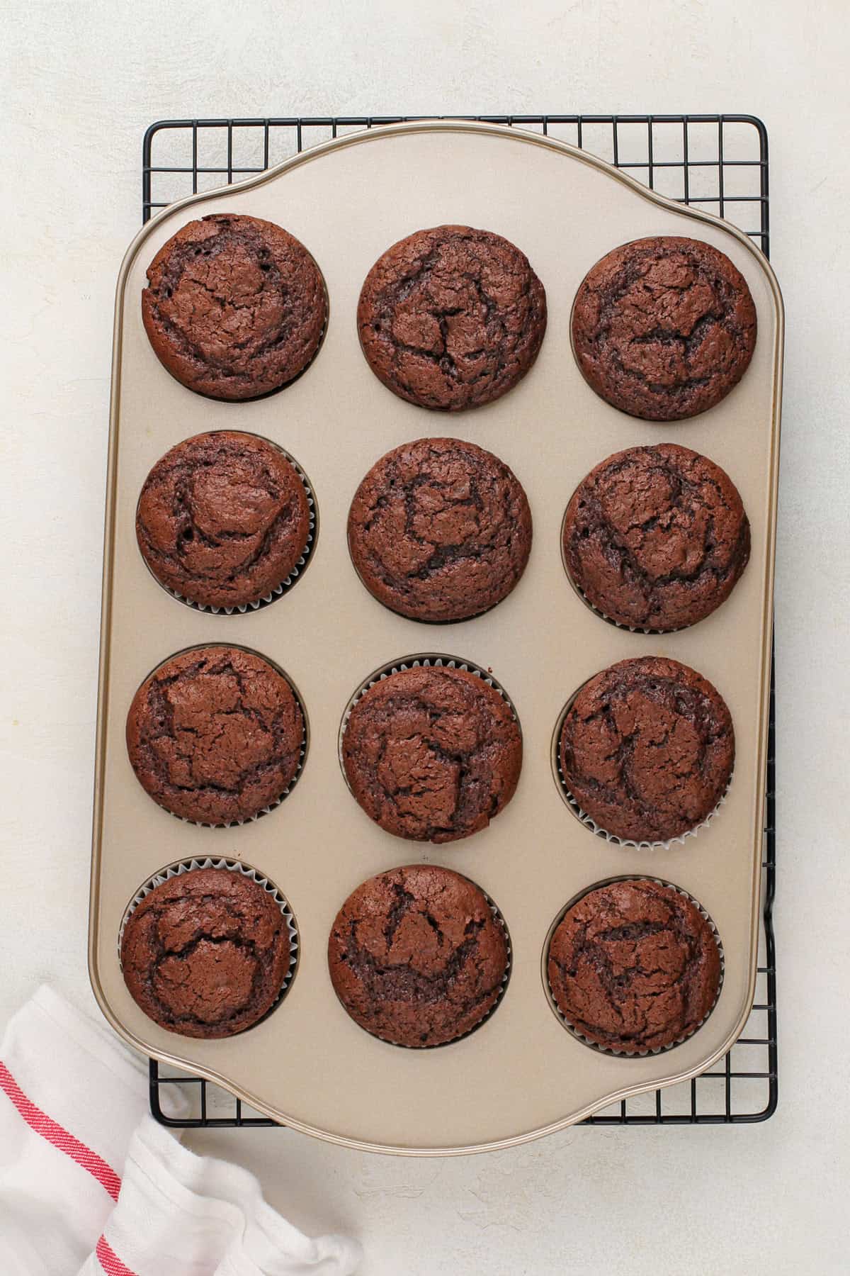 Baked chocolate cupcakes in a muffin tin.