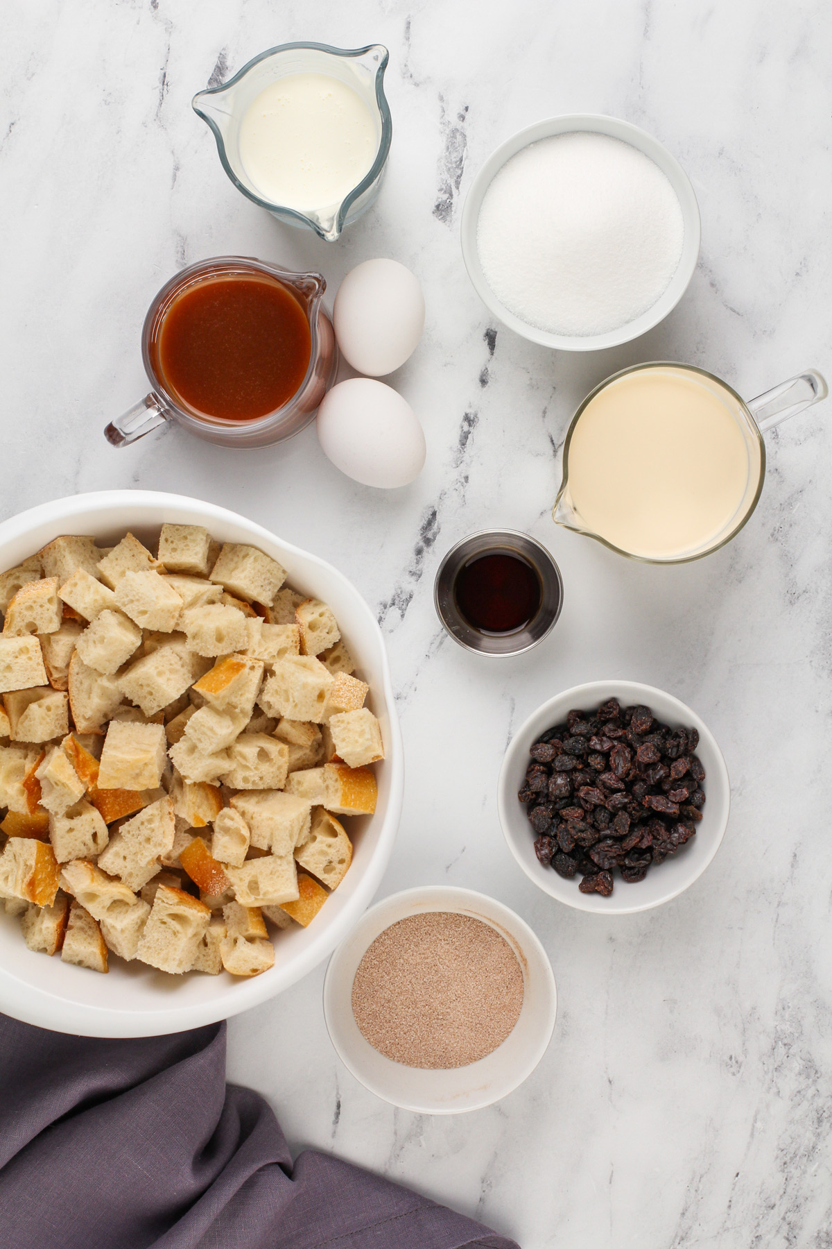 Ingredients for irish bread pudding arranged on a marble countertop.