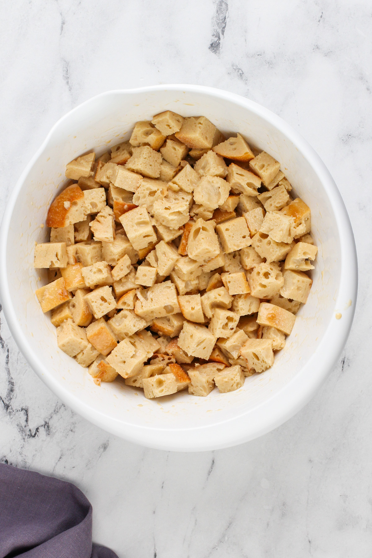 Mixture for irish bread pudding in a white bowl.