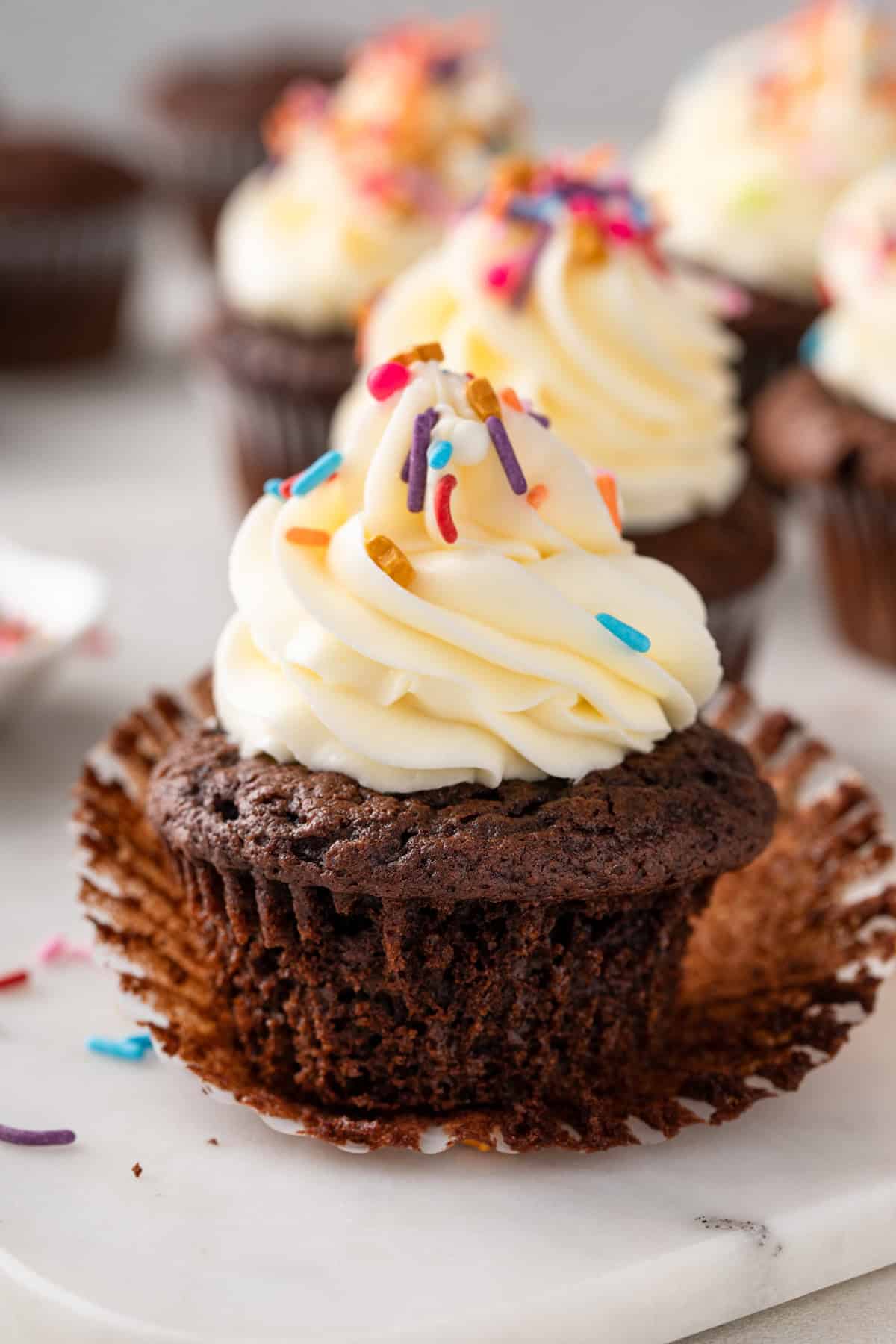 Chocolate cupcake made with doctored cake mix unwrapped on a countertop.