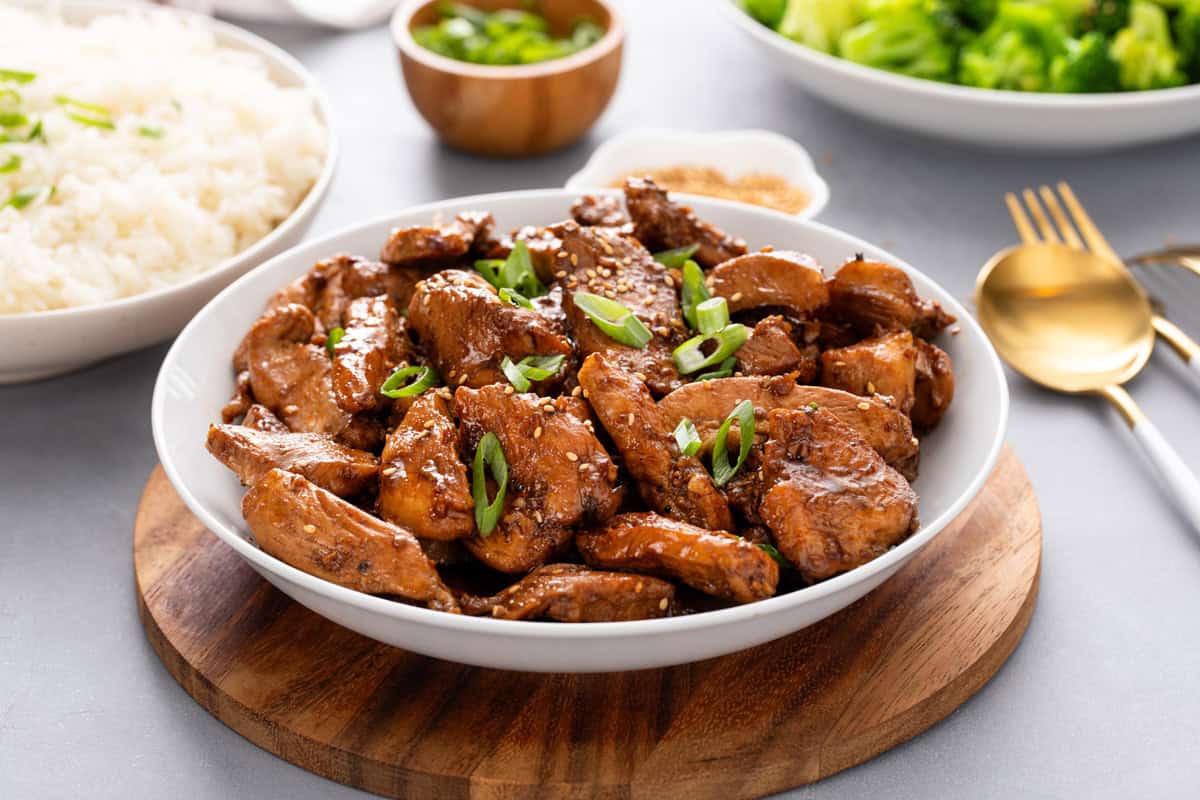 White serving bowl filled with honey soy chicken.