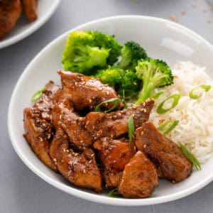 Honey soy chicken in a bowl with rice and broccoli.