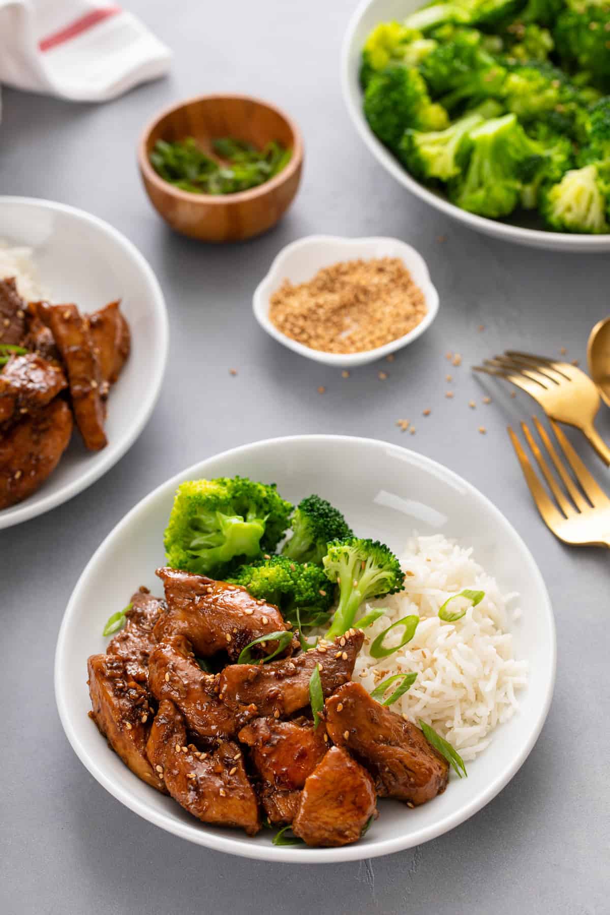 White bowl filled with honey soy chicken, rice, and broccoli.