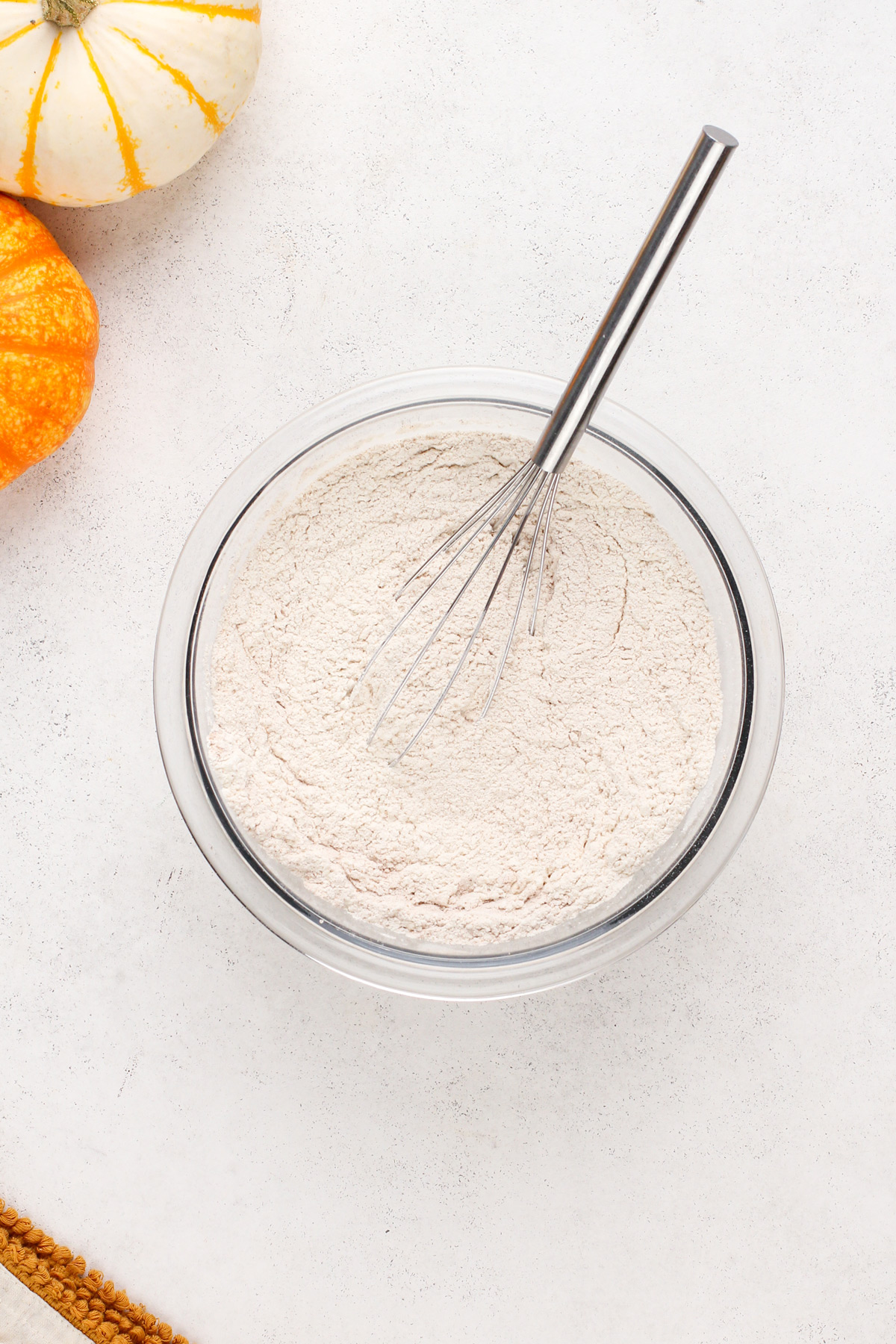 Dry ingredients for pumpkin bread whisked in a glass bowl.