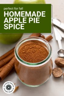 Jar filled with apple pie spice surrounded by cinnamon sticks, nutmeg, and apples. Text overlay includes recipe name.