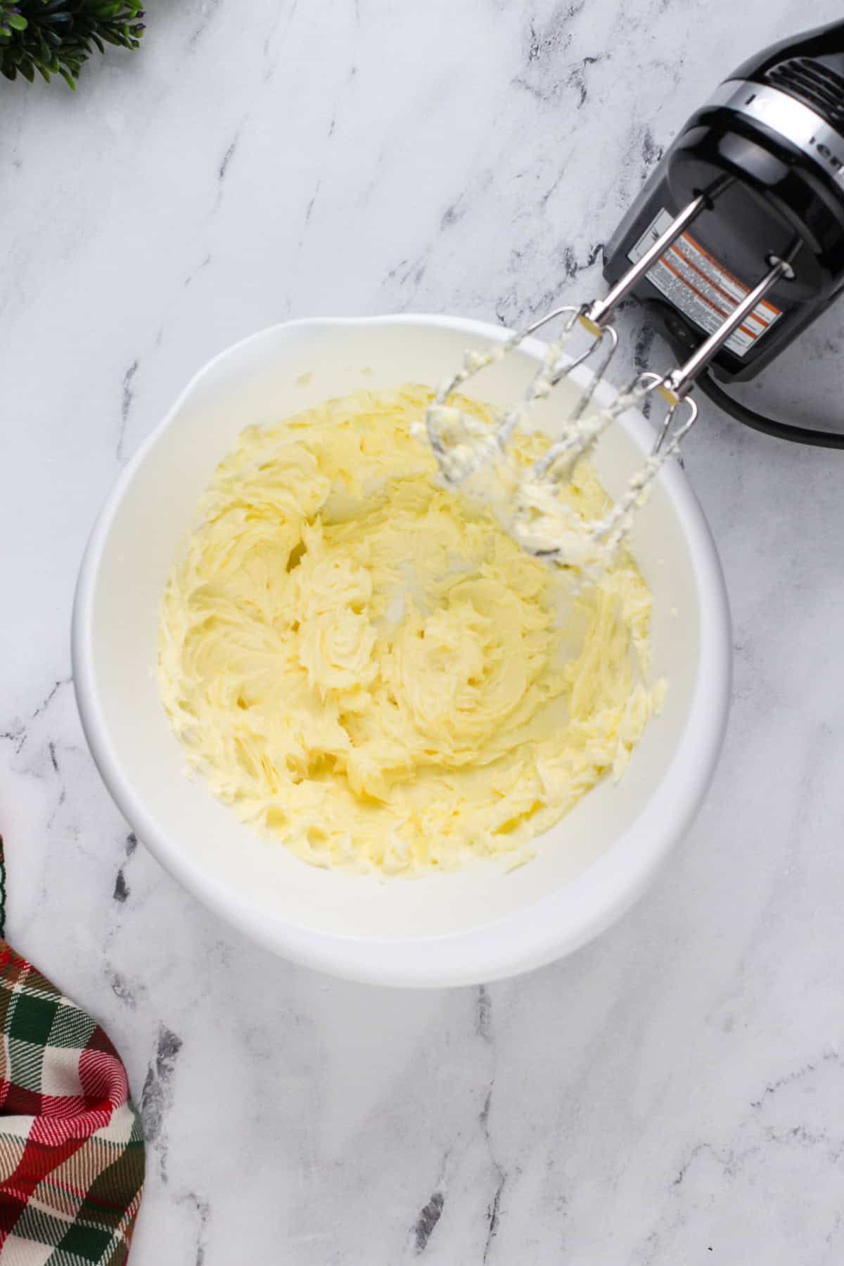 Butter and powdered sugar beaten in a white bowl.