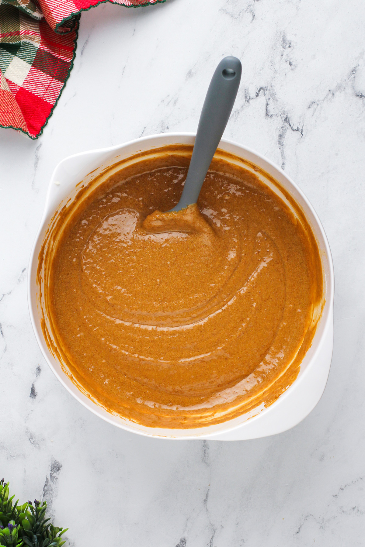 Cake batter for gingerbread cake in a white mixing bowl.