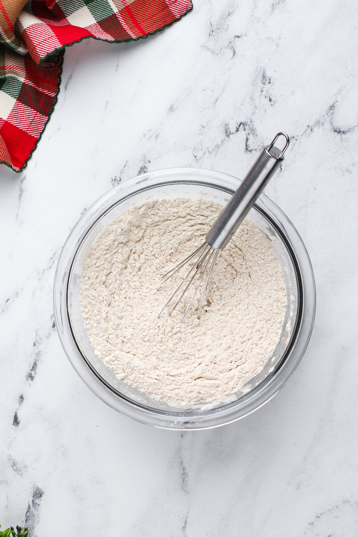 Dry ingredients for gingerbread cake whisked in a glass bowl.