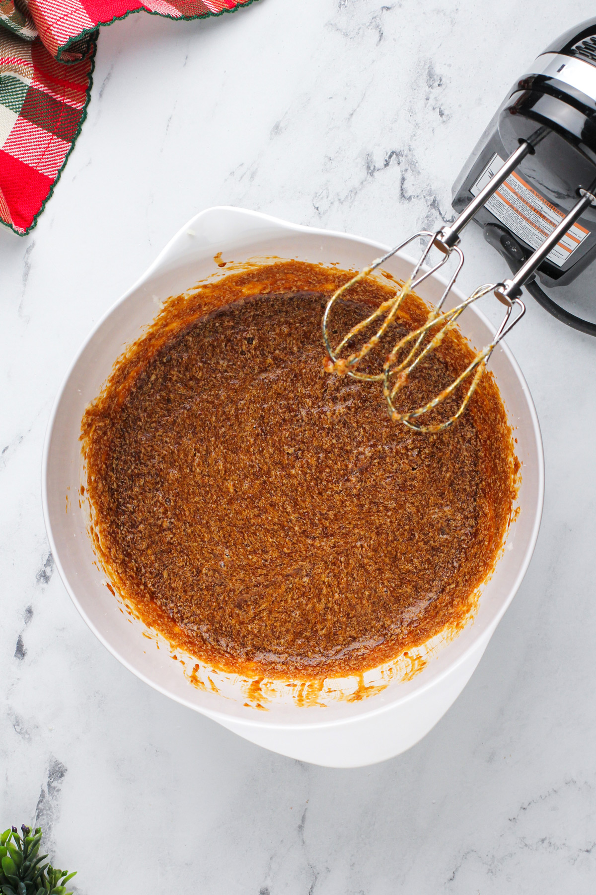 Wet ingredients for gingerbread cake mixed in a white bowl.