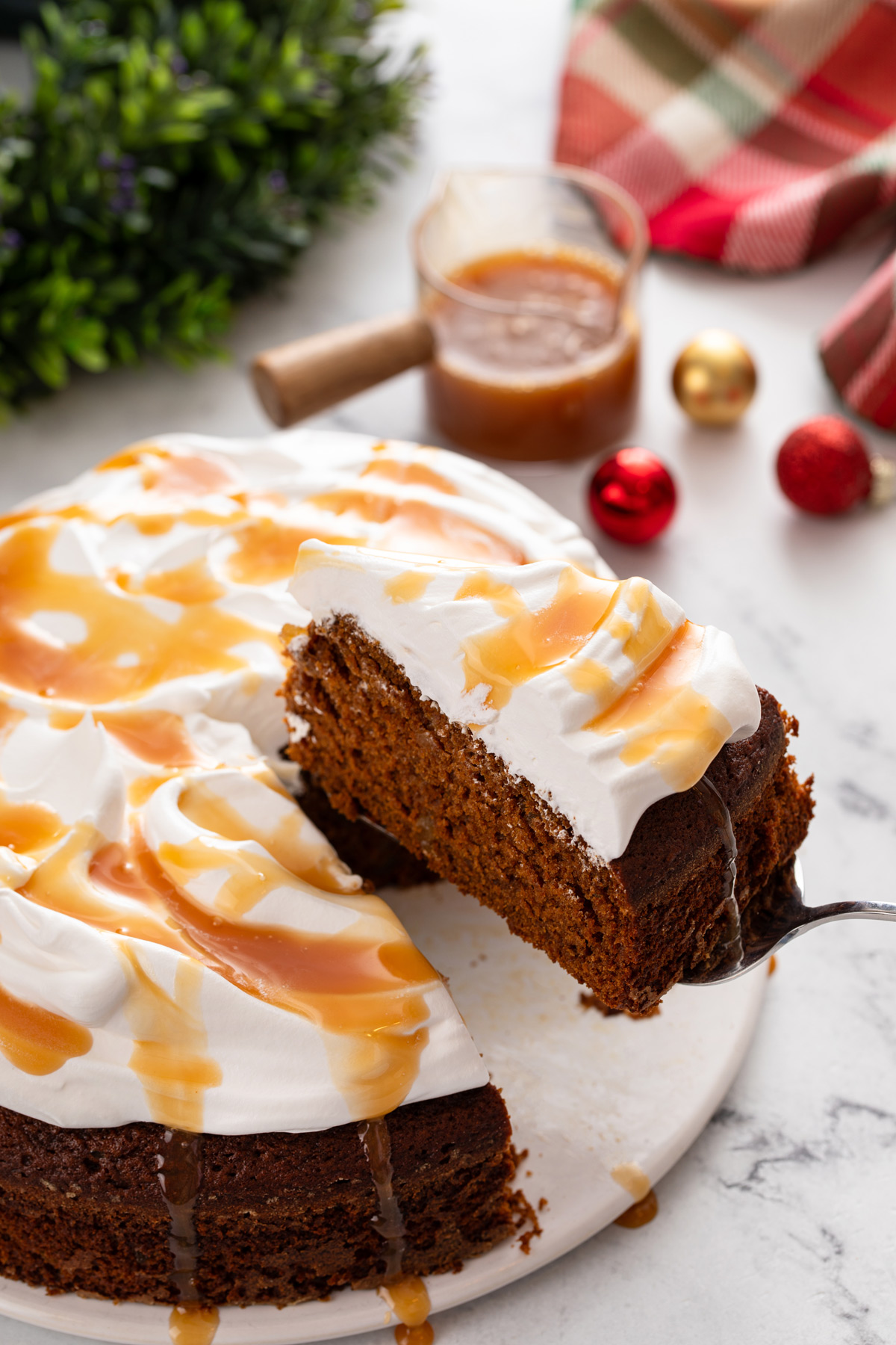 Cake server lifting up a slice of garnished gingerbread cake.