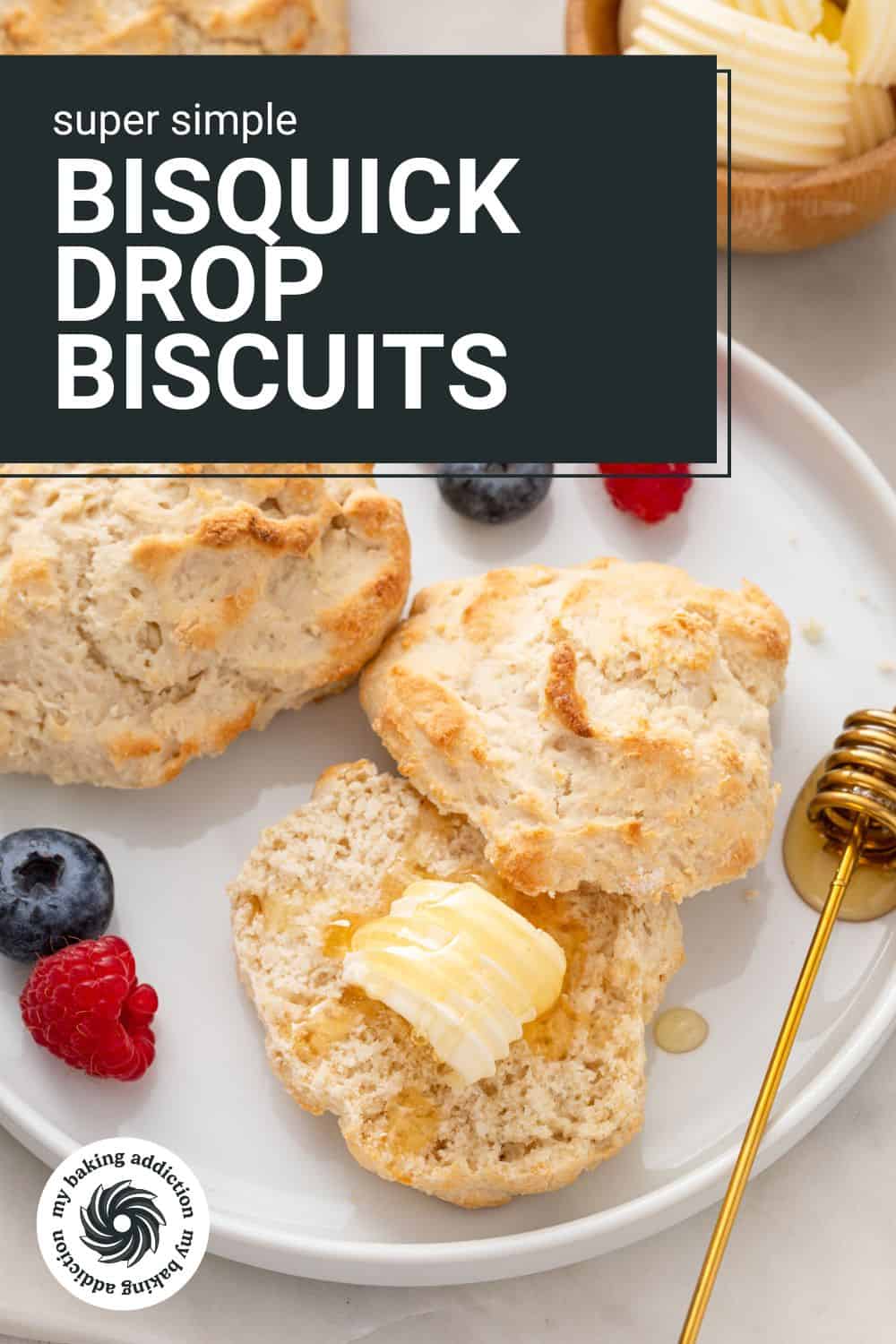 Two bisquick biscuits on a white plate next to fresh fruit. One of the biscuits is cut in half and covered in butter and honey. The text overlay includes the recipe name.